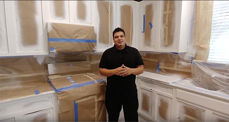 Austin branch manager Lex in front of primed kitchen cabinets