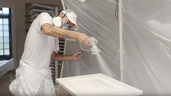 Pro painter spraying a cabinet door for kitchen painting project, Alamo Heights