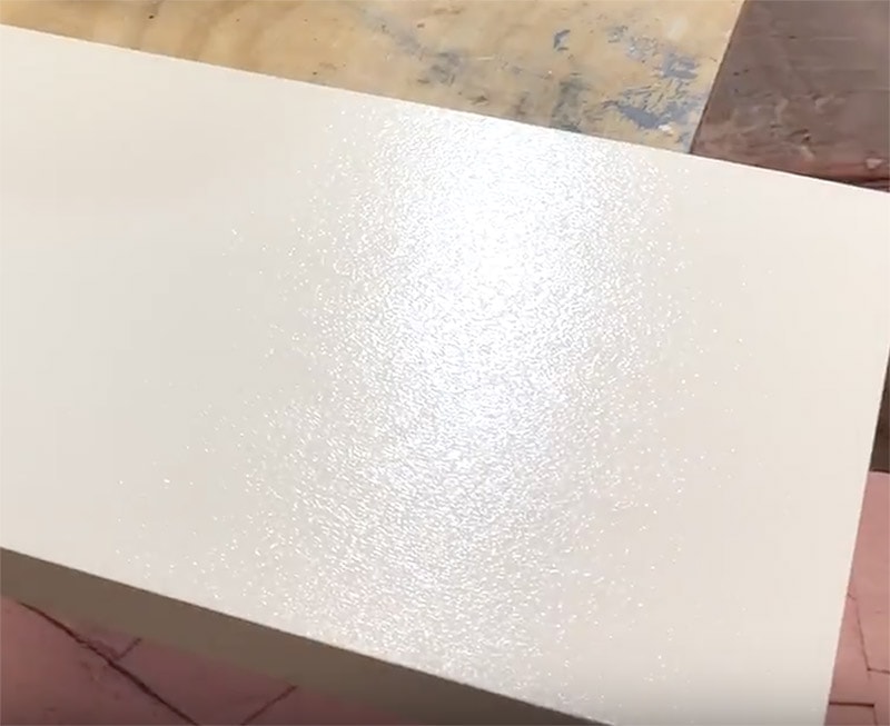 White painted cabinet door with visible roller stipple marks