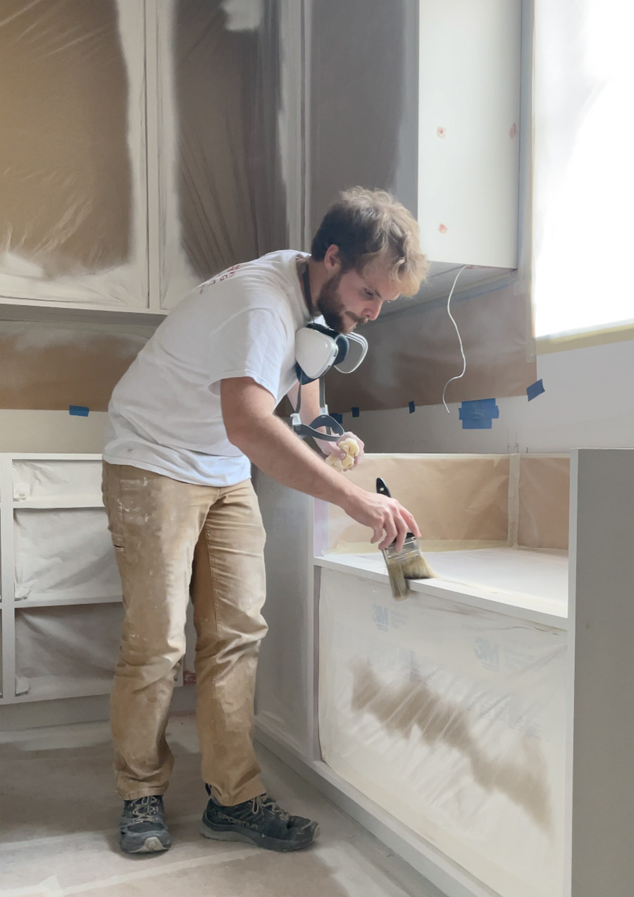 cabinet-painter-dusting-off-primed-cabinets-austin-tx